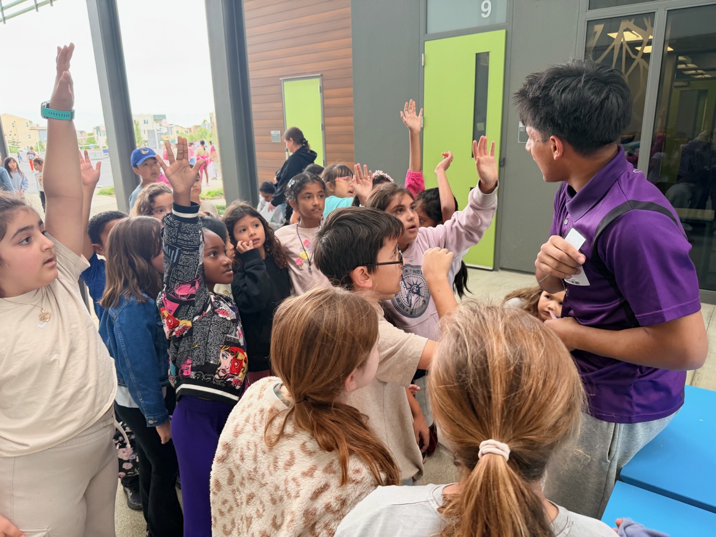 Kids raising hands during a workshop